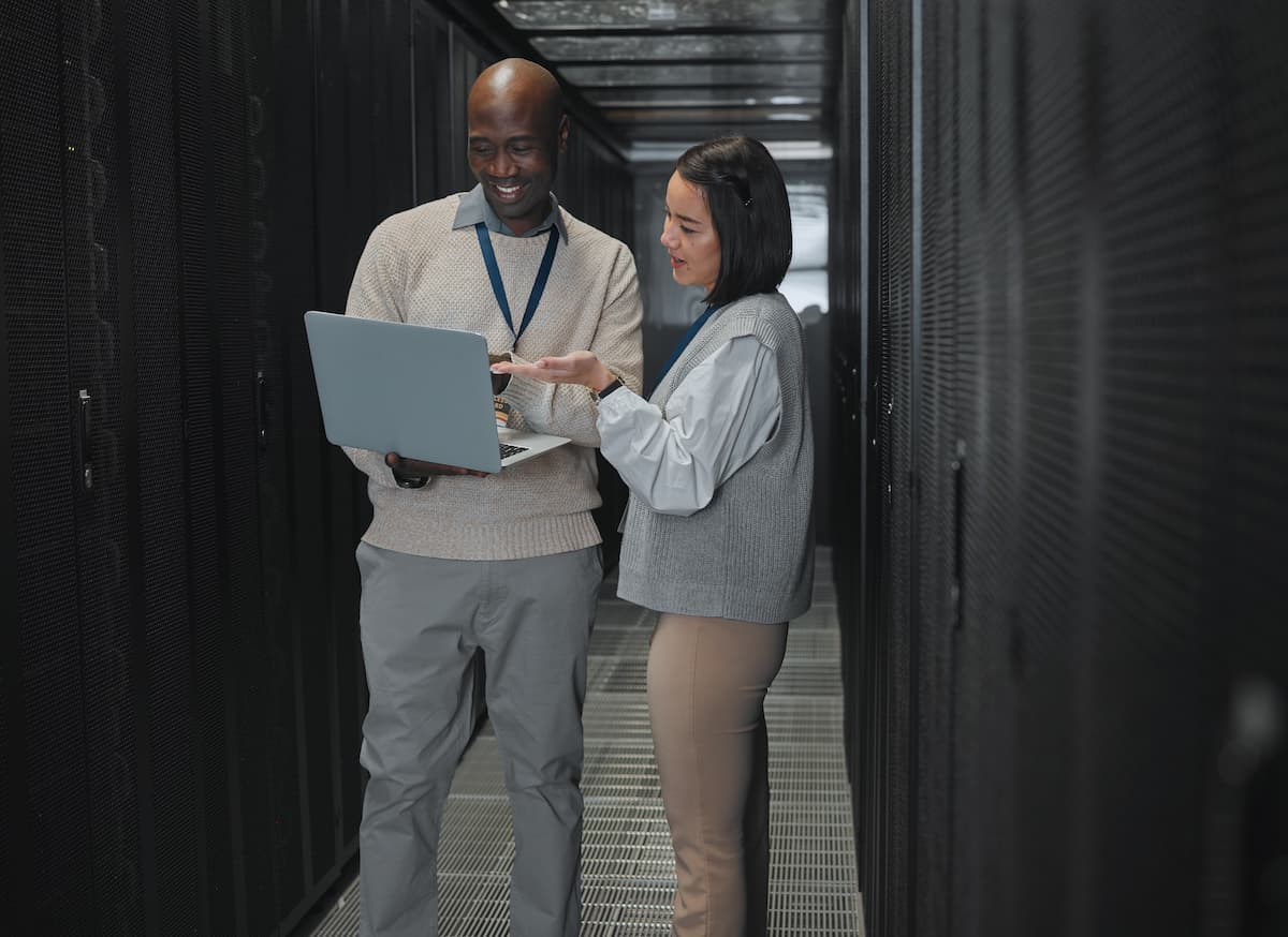 two people in a server room review their company's data backup strategy