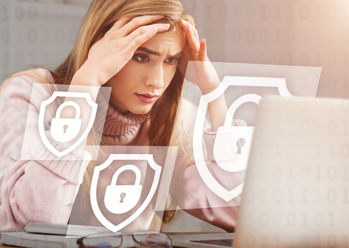 upset woman holds her head with hands and looks at locked computer